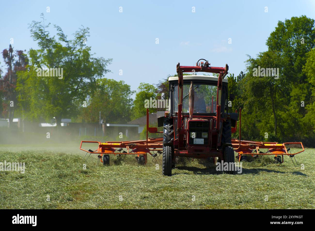 Trattore in primavera alla curva del fieno Foto Stock