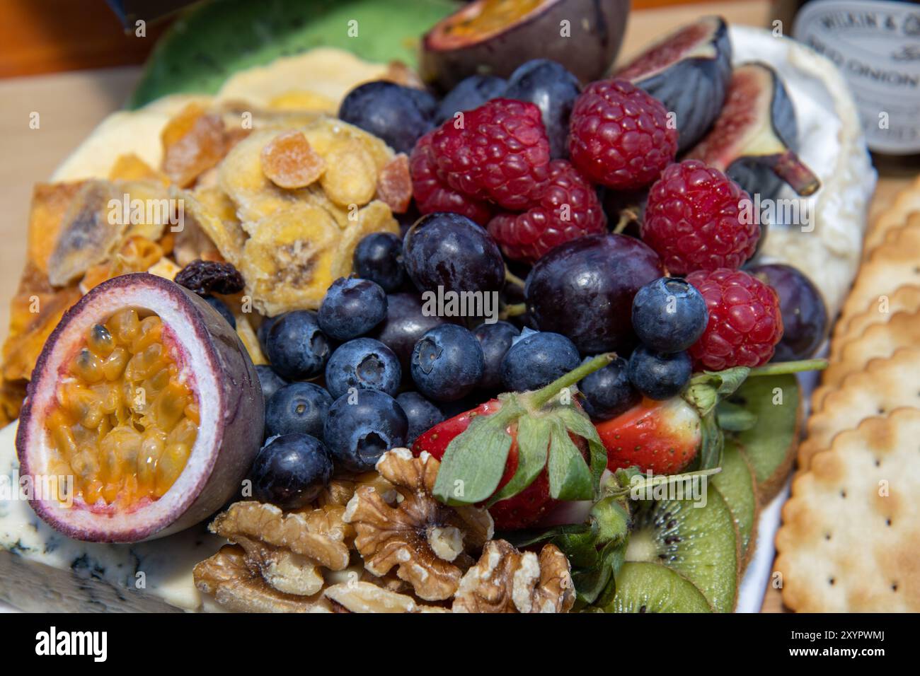 Ampia scelta di frutta e noci su un piatto, tra cui mirtilli, frutto della passione e molto altro Foto Stock
