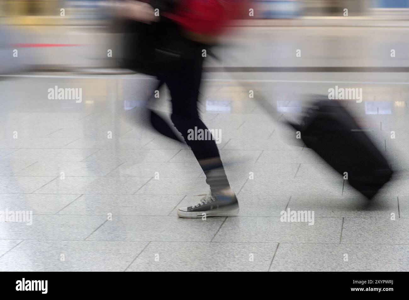 Una persona che porta dietro un carrello Foto Stock