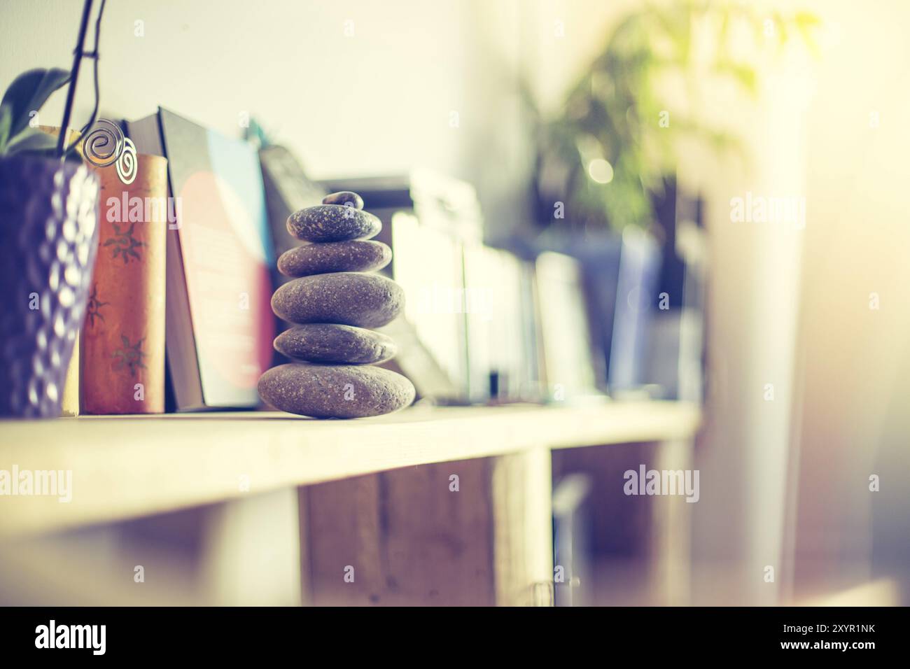 Feng Shui: Cairn di pietra in primo piano, salotto sfocato sullo sfondo. Equilibrio e relax Foto Stock