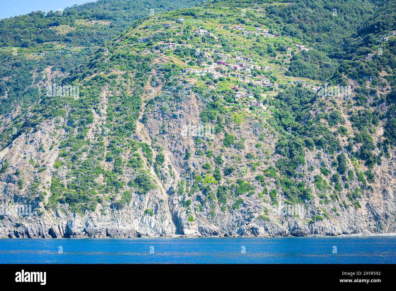 Scogliera ripida con in cima il Villaggio di Campiglia tramonti n Parco Nazionale delle cinque Terre sul Mar Ligure, Italia Foto Stock