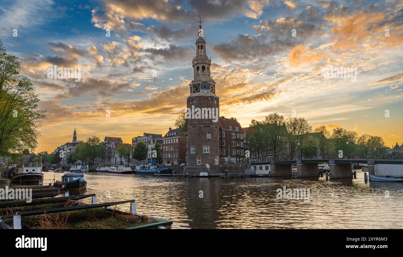 Il Montelbaanstoren al tramonto. Storica torre di difesa situata sulla riva del canale Oudeschans ad Amsterdam, Paesi Bassi Foto Stock