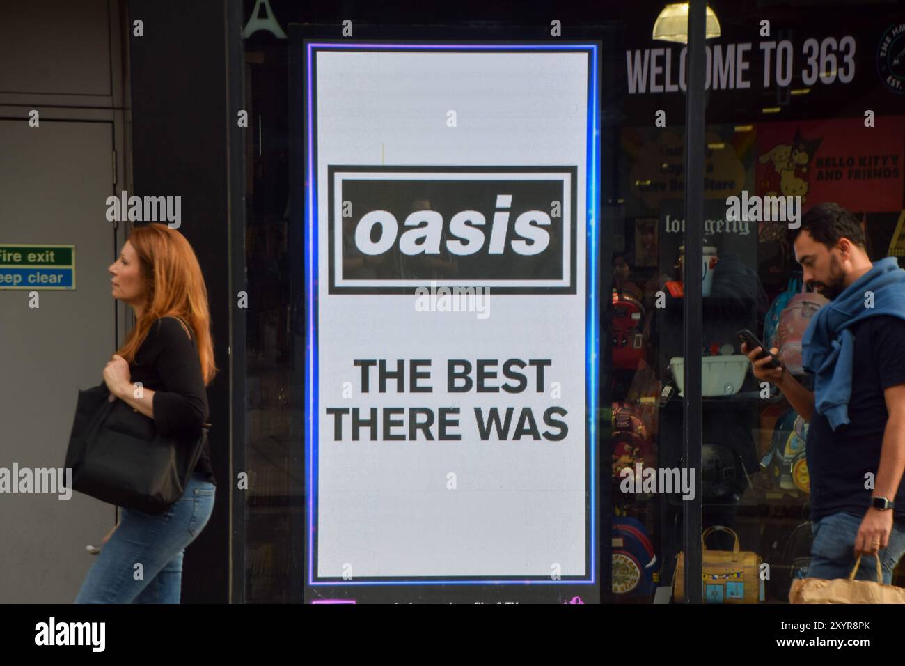 Londra, Inghilterra, Regno Unito. 30 agosto 2024. Le persone passano davanti a uno schermo all'HMV Oxford Street promuovendo l'uscita dell'edizione del 30° anniversario di 'Definitely Maybe', l'album di debutto degli Oasis, mentre la rock band di Manchester annuncia altri spettacoli di riunione dopo 15 anni. (Credit Image: © Vuk Valcic/ZUMA Press Wire) SOLO PER USO EDITORIALE! Non per USO commerciale! Crediti: ZUMA Press, Inc./Alamy Live News Foto Stock