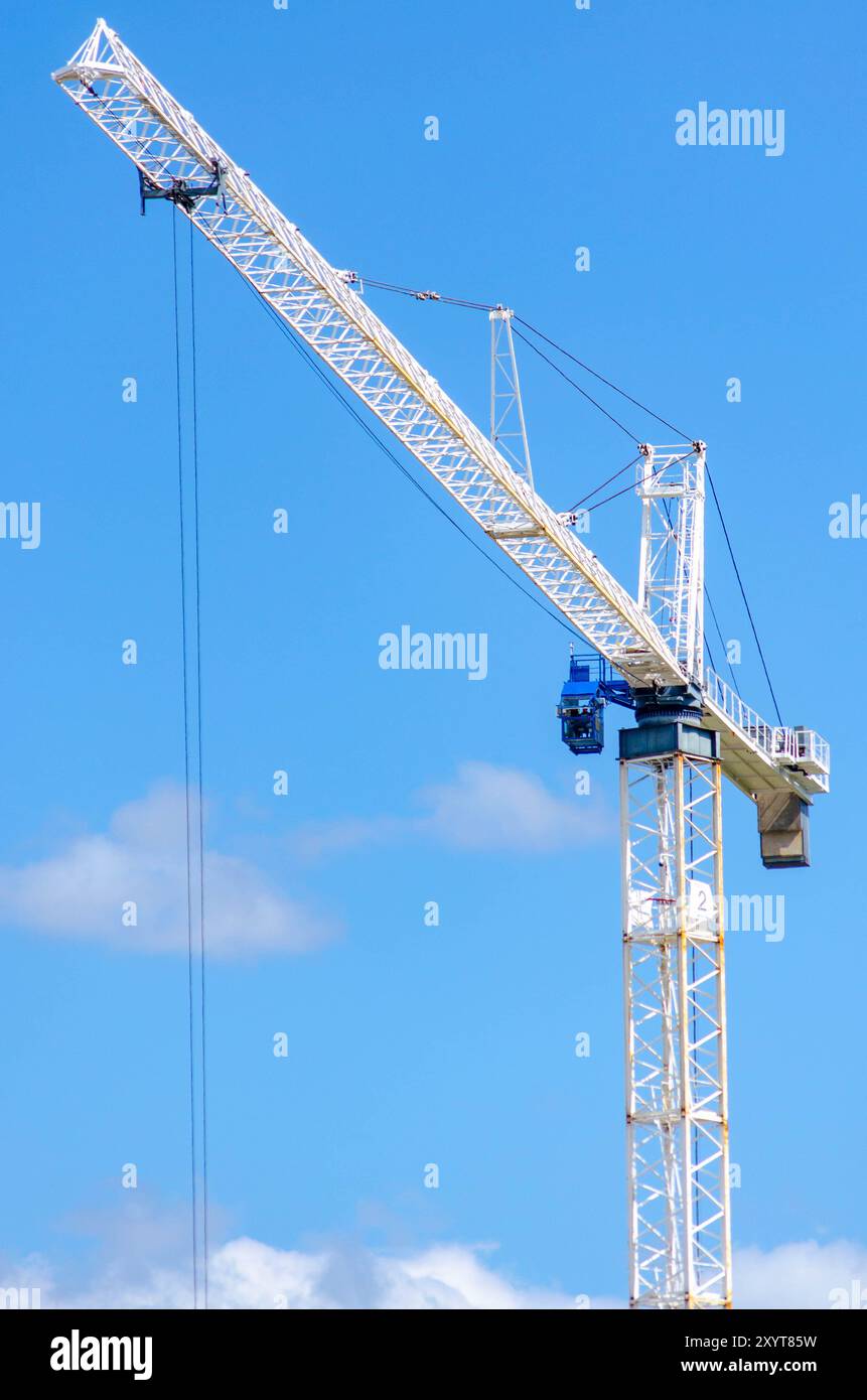 White Tower Crane con Un cielo azzurro trasparente in Un cantiere edile Foto Stock