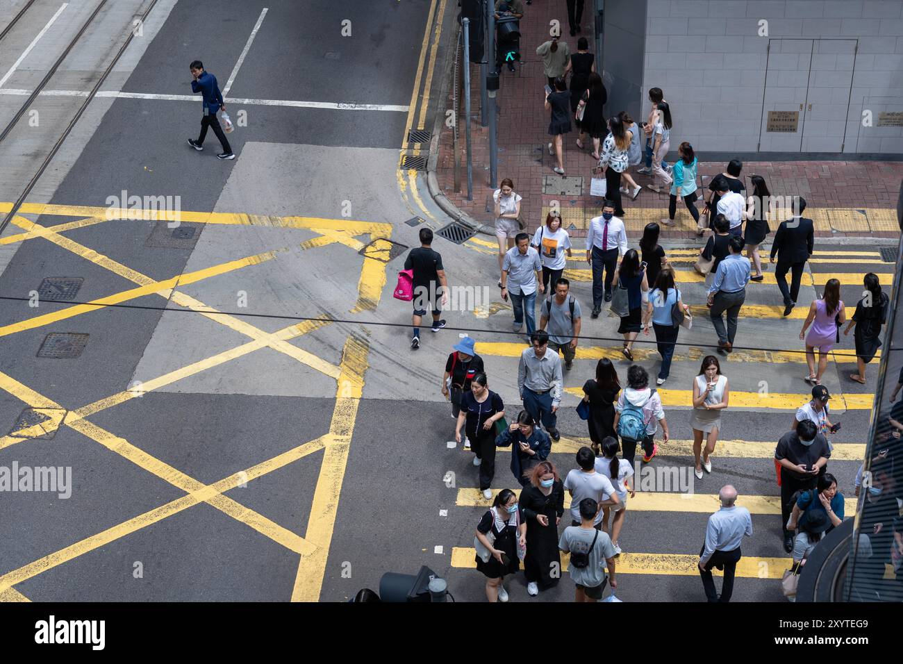 Hong Kong, Cina - 3 luglio 2024: Veduta aerea di un incrocio di Hong Kong Street, che mostra i pedoni che attraversano la strada segnata da linee gialle. Foto Stock