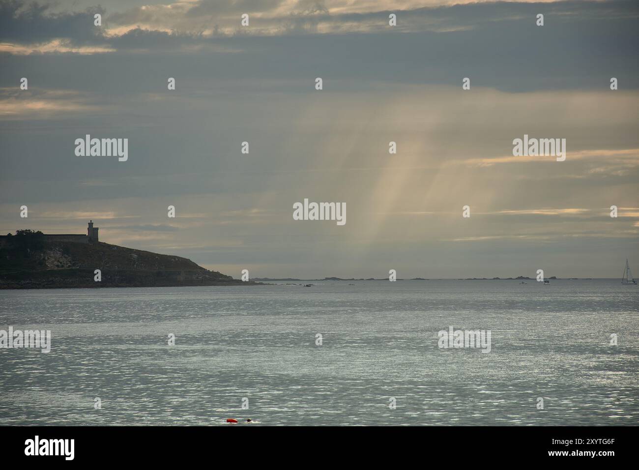 La tranquilla bellezza di Playa America al tramonto, con il Castello di Monte Real sullo sfondo. I raggi d'oro del sole tramonta attraversano t Foto Stock