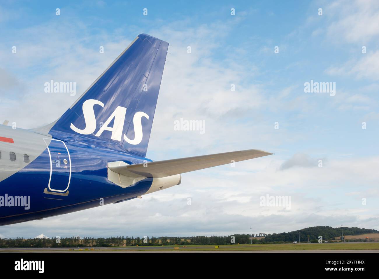 Edimburgo, Scozia - 7 agosto 2024: Ala di coda e logo SAS - Scandinavian Airlines - aereo su un aeroporto contro il cielo blu nuvoloso Foto Stock