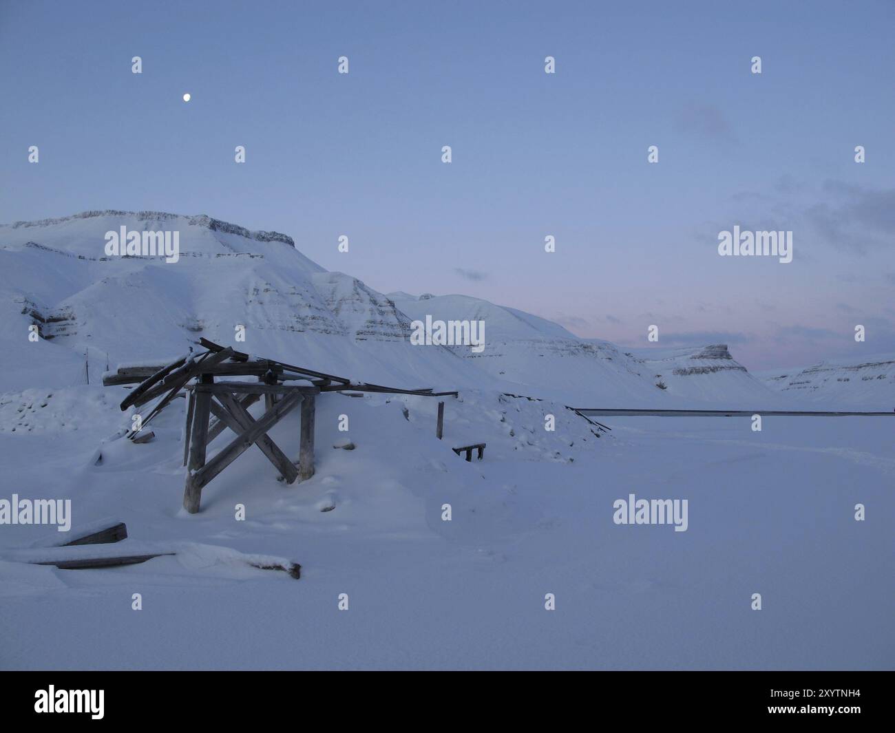 Resti di una vecchia miniera di gesso in Skansbukta prima del sorgere del sole con la luna, Spitsbergen Foto Stock