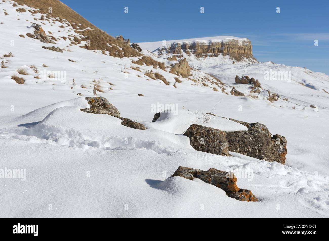 Il paesaggio di rocce caucasiche innevate sul passo Gumbashi. Altopiano innevato che passa nella montagna da tavolo con pietre megalitiche nel Foto Stock