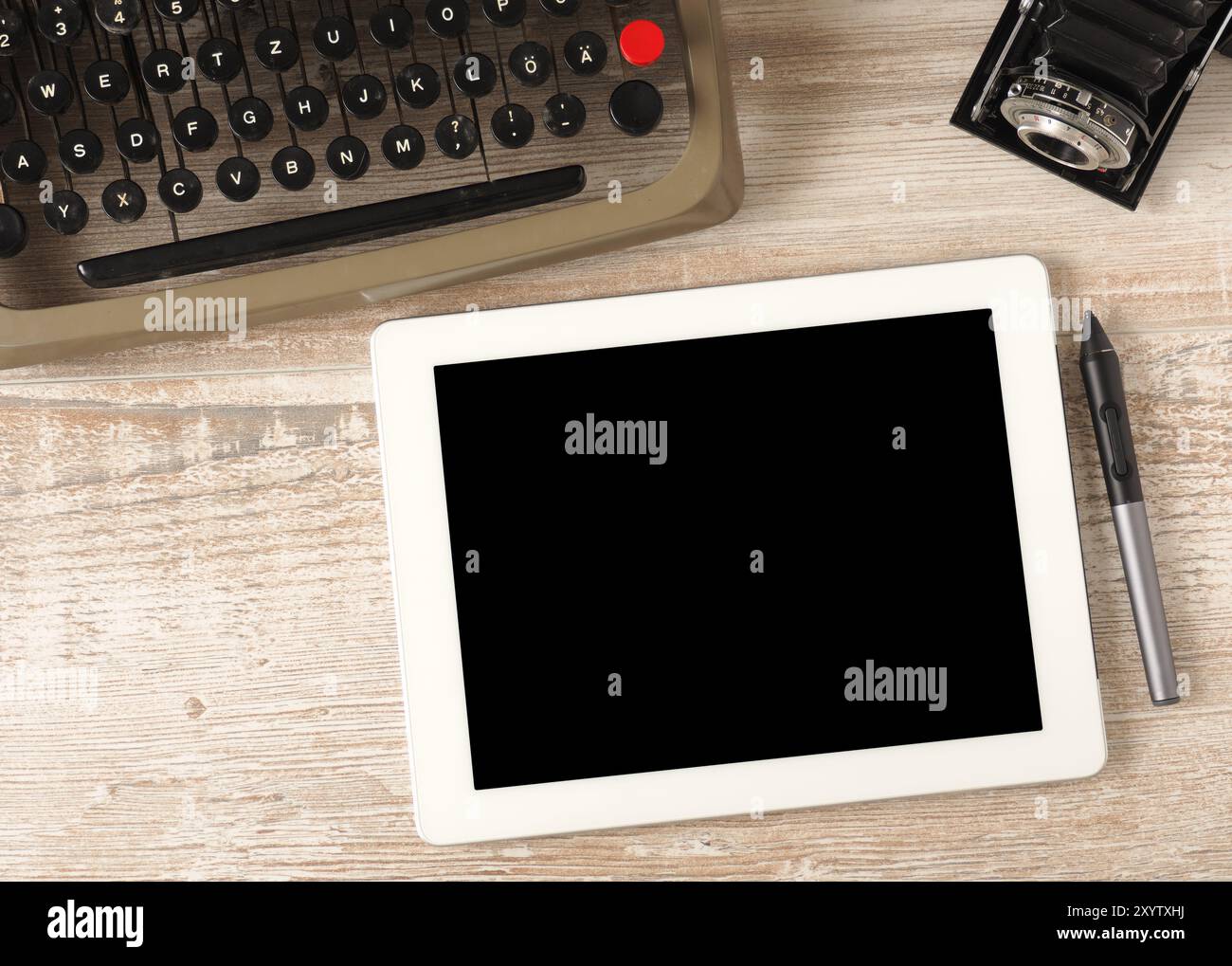 Vista dall'alto su una scrivania in ufficio con una vecchia macchina da scrivere e vintage fotocamera con tablet pc e la penna Foto Stock