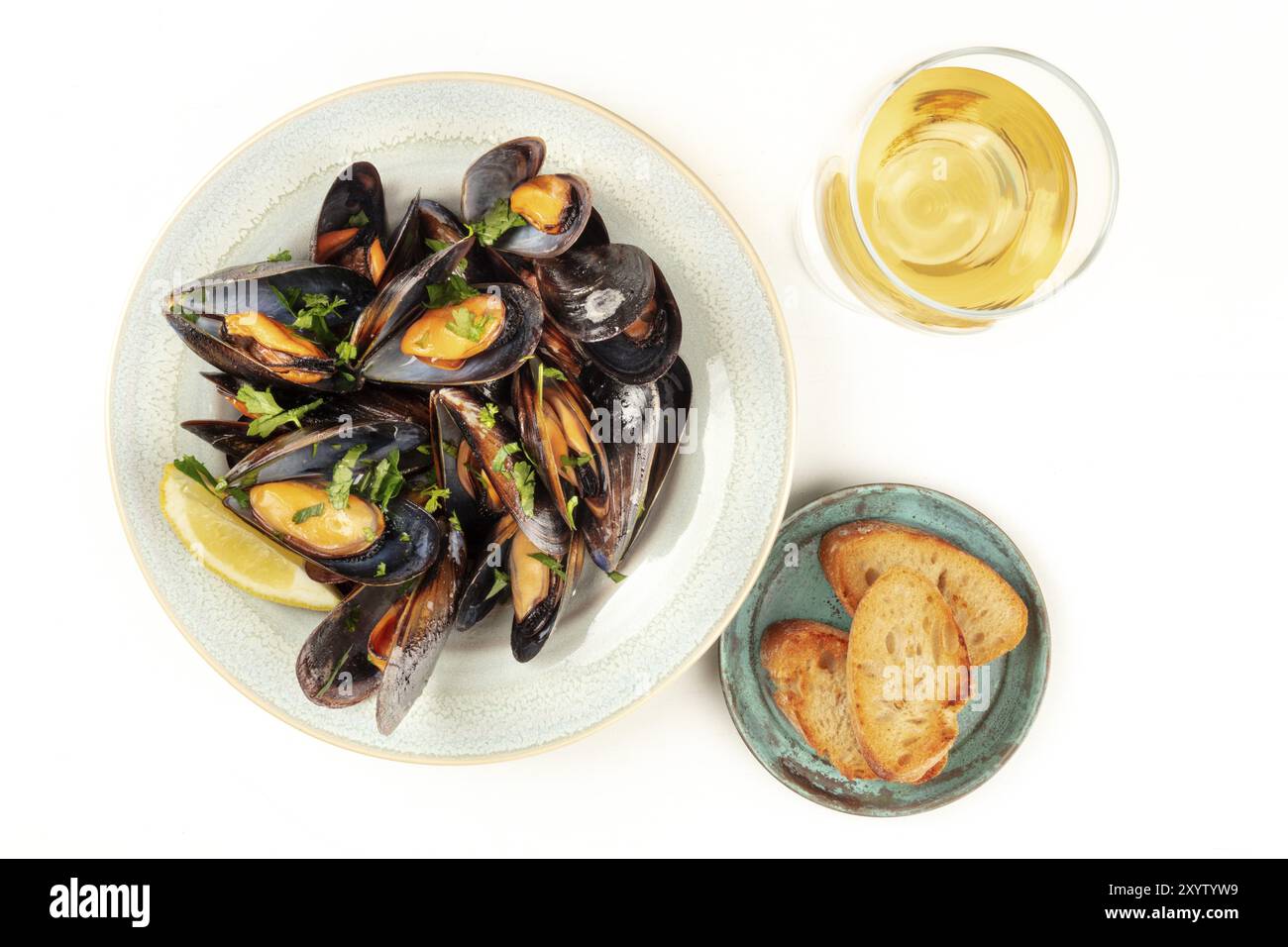 Cozze alla marinara, moules mariniere, ripresa dall'alto su un fondo bianco con un bicchiere di vino, pane tostato e un posto per il testo Foto Stock