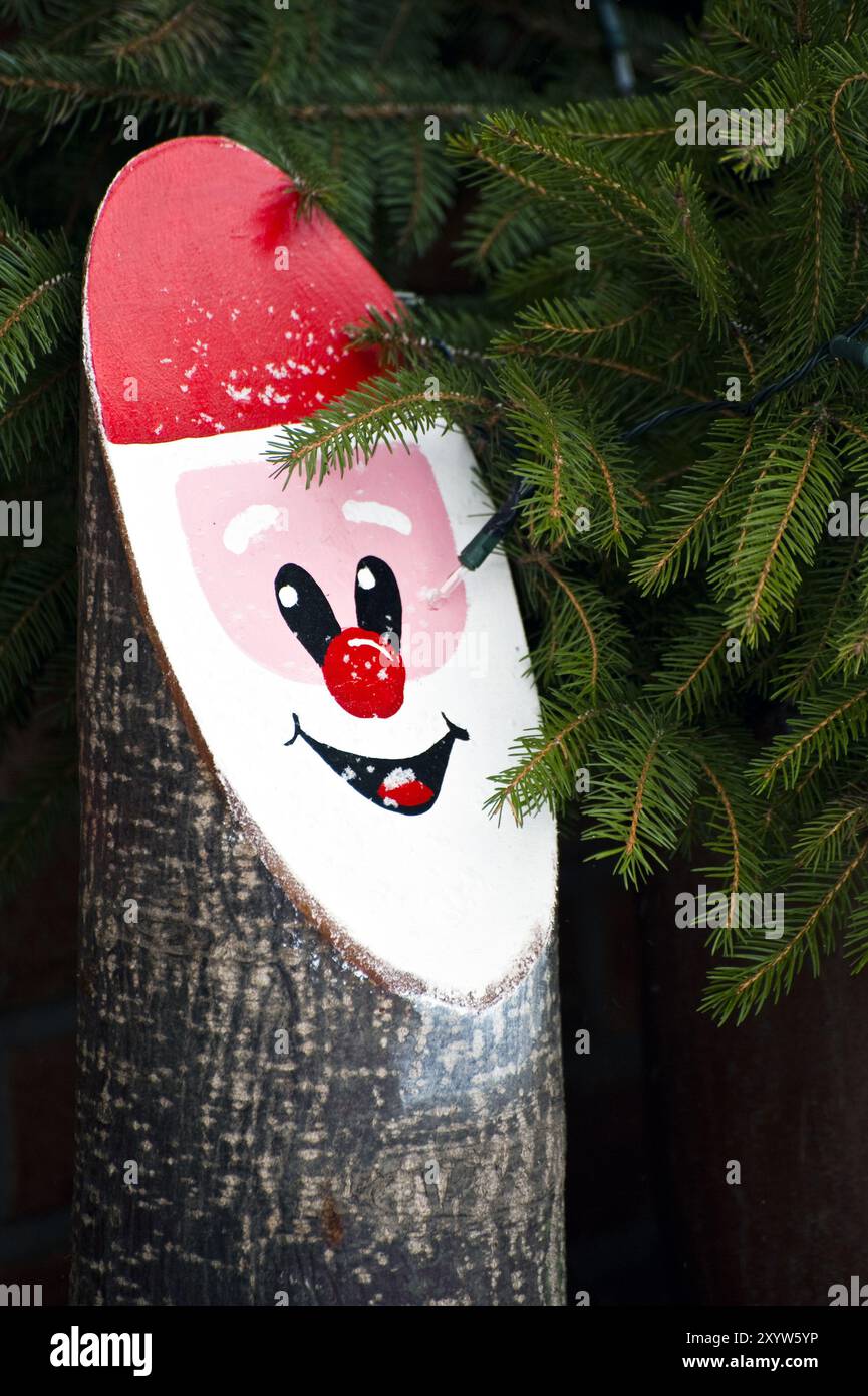 La faccia di padre Christmas sulla superficie tagliata di un tronco d'albero Foto Stock