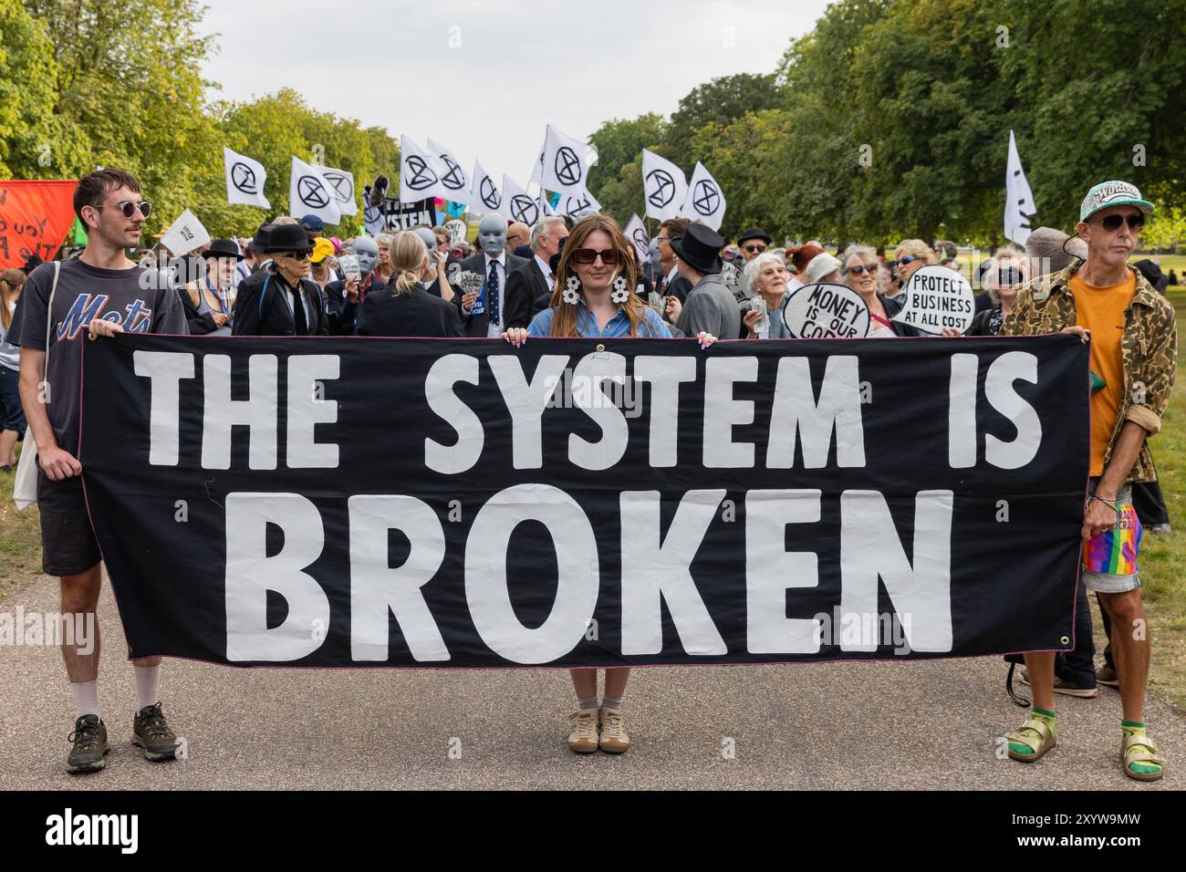 Windsor, Regno Unito. 30 agosto 2024. Gli attivisti per il clima di Extinction Rebellion organizzano una protesta "il sistema è rotto" durante la lunga passeggiata fuori dal Castello di Windsor durante il primo dei tre giorni di attività di Upgrade Democracy. La campagna “Upgrade Democracy” di Extinction Rebellion ha lo scopo di evidenziare il modo in cui i profitti sono salvaguardati per le compagnie petrolifere e del gas nel Regno Unito e di invitare il governo britannico a creare e a essere guidato da un’Assemblea dei cittadini sul clima e la giustizia ecologica. Crediti: Mark Kerrison/Alamy Live News Foto Stock