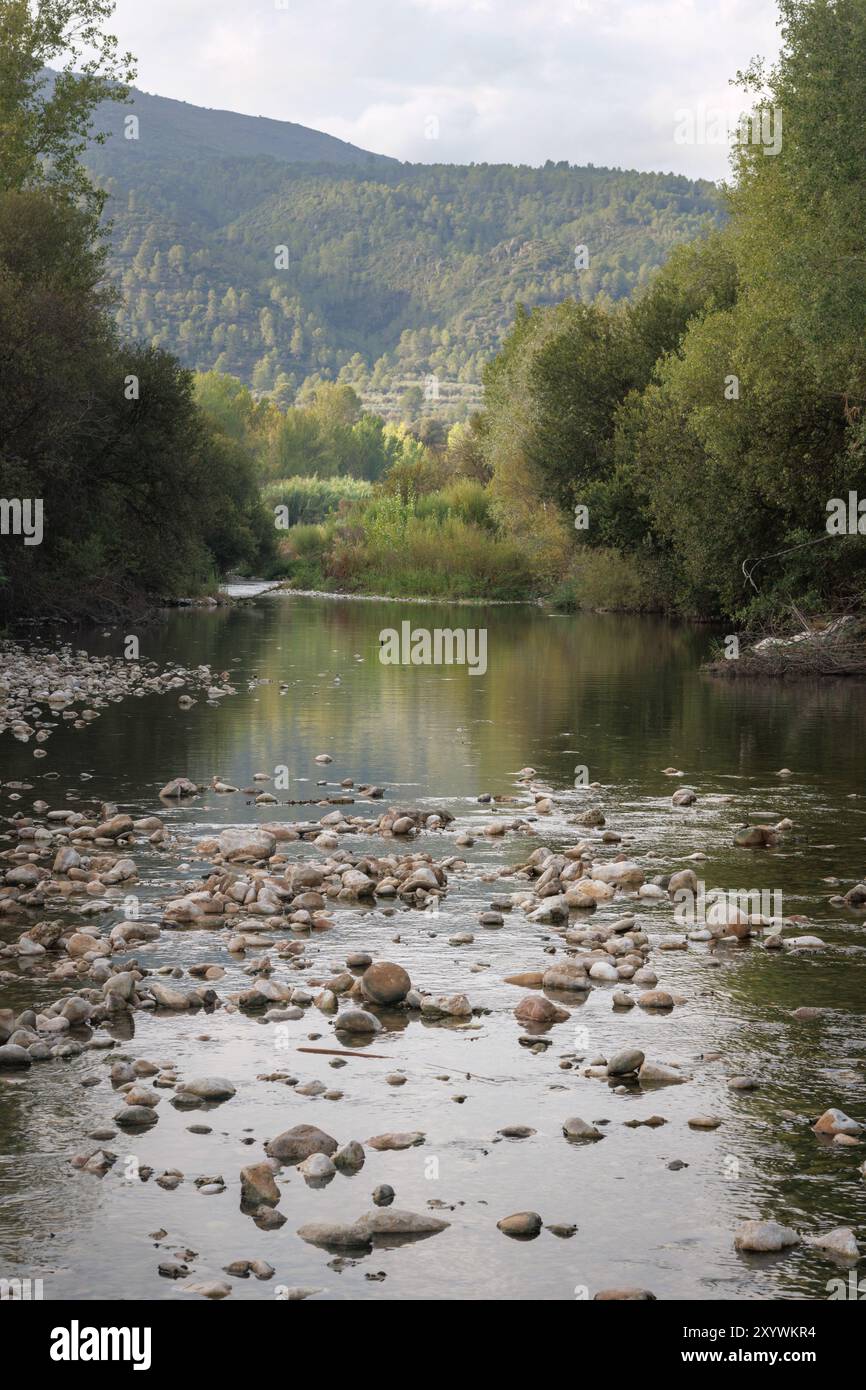 Paesaggio con il letto del fiume Serpis mentre passa attraverso Lorcha con un basso flusso d'acqua a causa dei cambiamenti climatici, Spagna Foto Stock