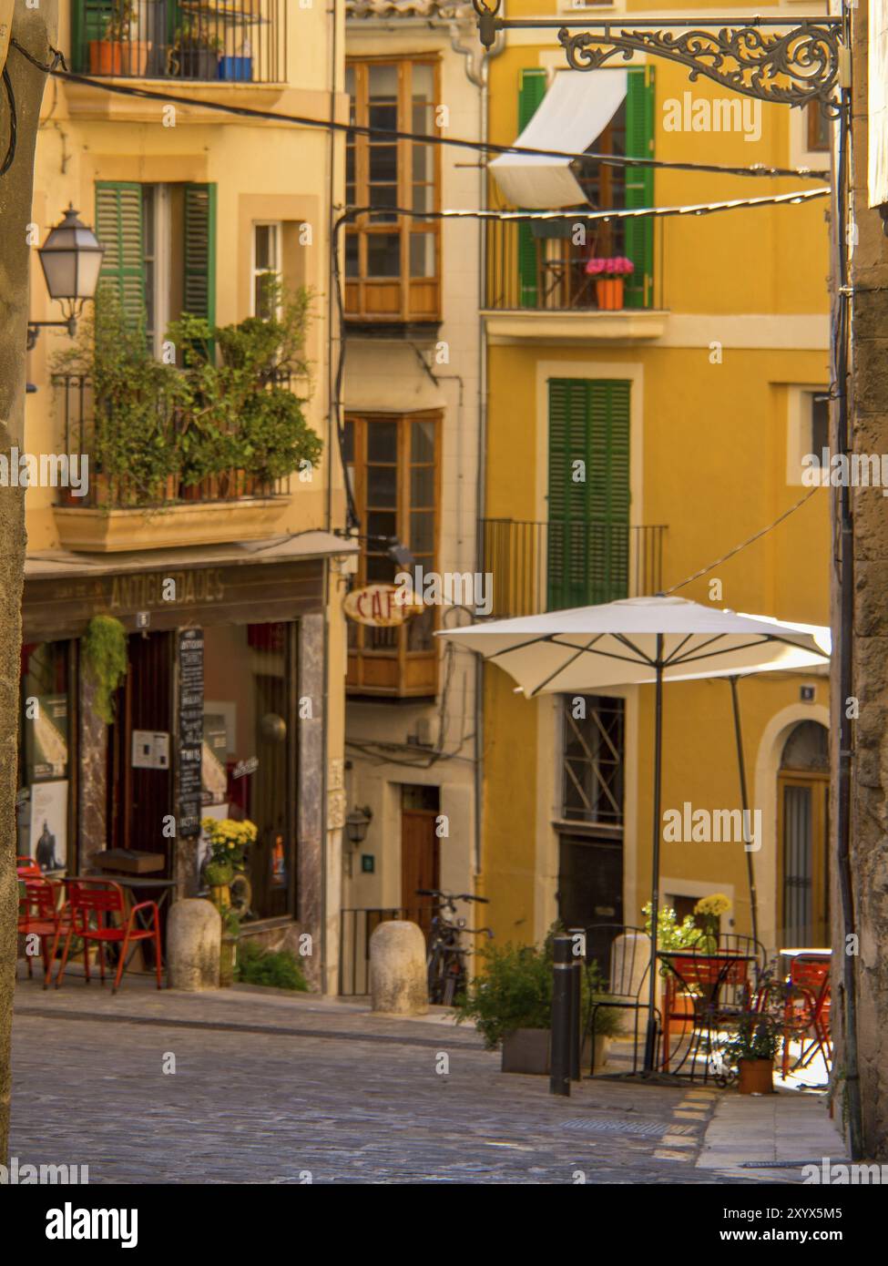 Vicolo affascinante con edifici colorati e un accogliente caffè con vicoli sotto ombrelloni, palma di Maiorca, maiorca, isole baleari, spagna Foto Stock