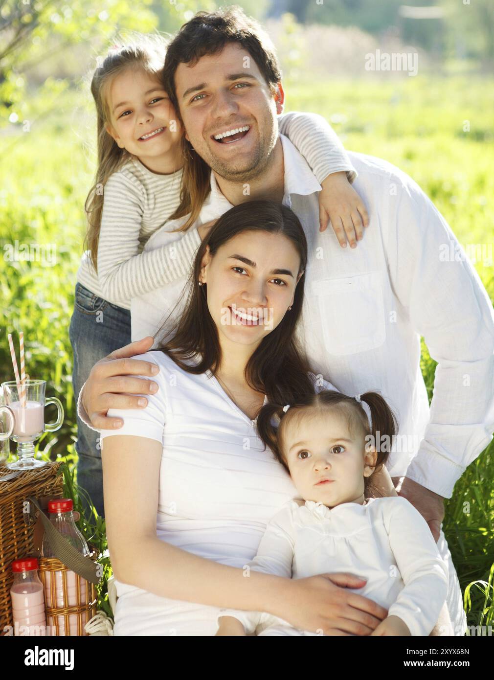 Felice giovane famiglia con due bambini al picnic a molla Foto Stock