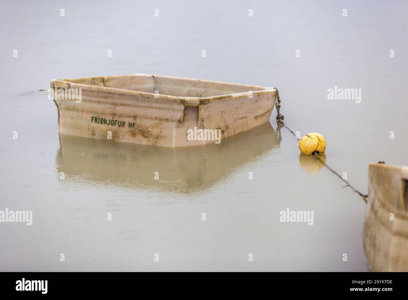 Due scatole di plastica bianche e una boa gialla sul lago Lagarfljot Foto Stock