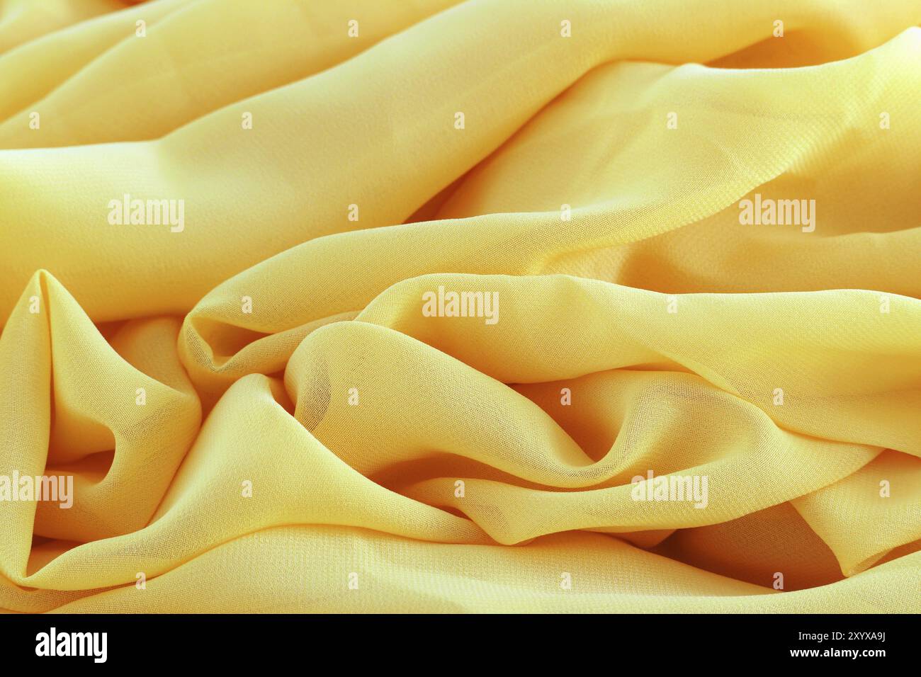 Consistenza di chiffon giallo nelle onde, può essere lo sfondo per tessuti e cuciture Foto Stock