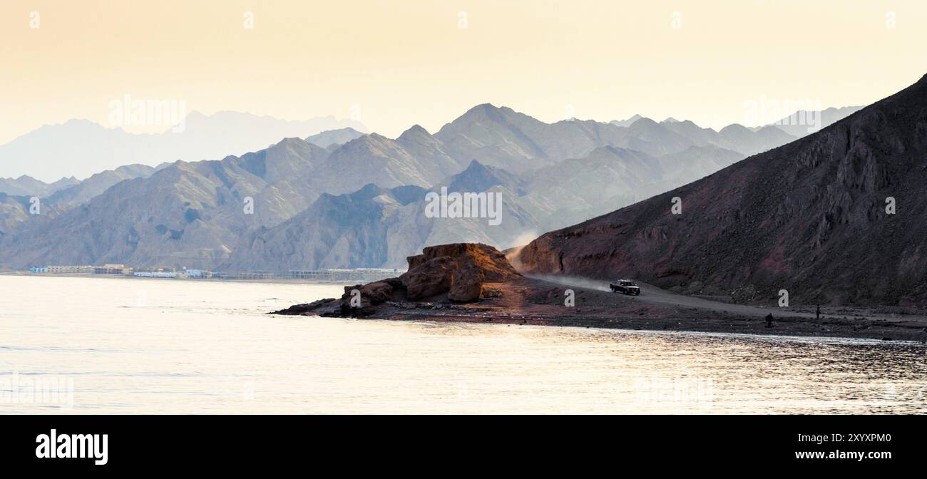 L'auto viaggia su una strada tra le montagne vicino alle rive del Mar Rosso in Egitto Foto Stock