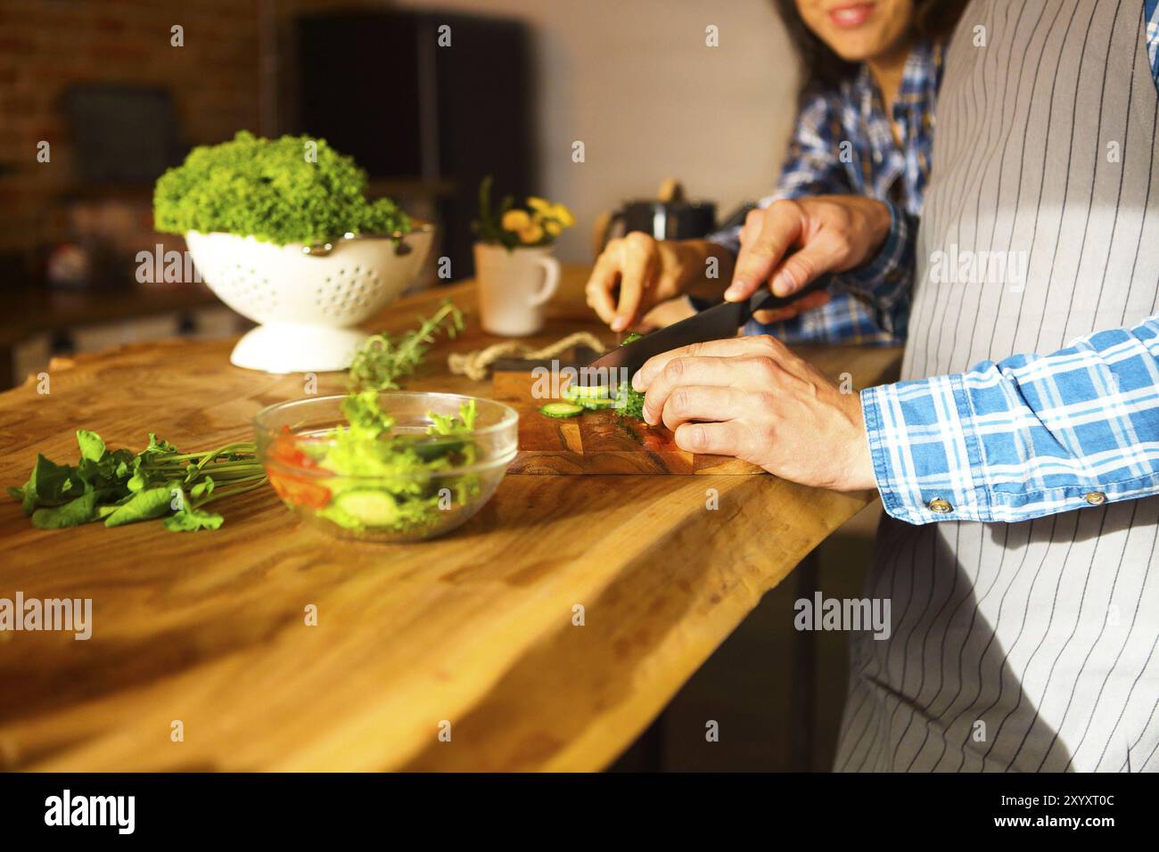 Giovane uomo e donna la cottura insalata di verdure insieme in cucina Foto Stock