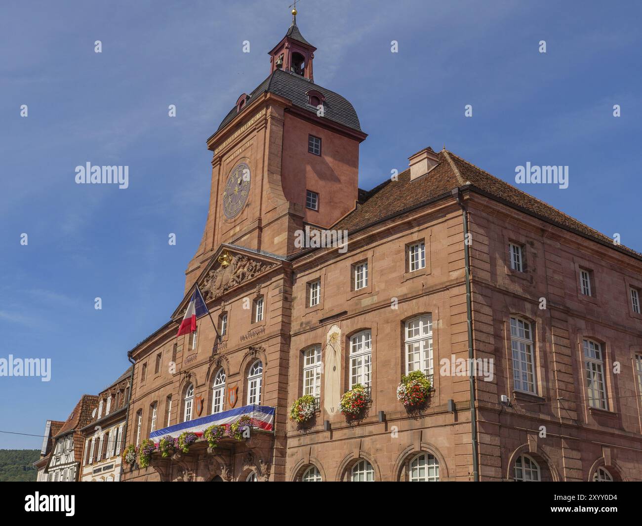 Storico municipio nel centro della città con torre dell'orologio e vasi decorativi sotto un cielo blu, Weissenburg, Alsazia, Francia, Europa Foto Stock