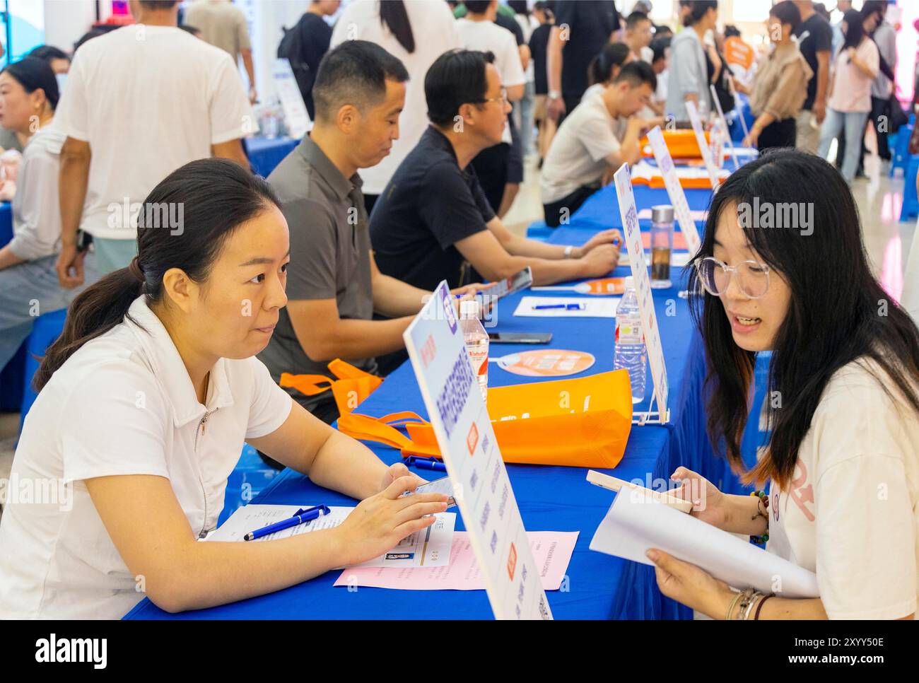 TAIZHOU, CINA - 31 AGOSTO 2024 - chi cerca lavoro comunica con i datori di lavoro in una fiera del lavoro a Taizhou, provincia di Jiangsu, Cina, 31 agosto 2024. Foto Stock