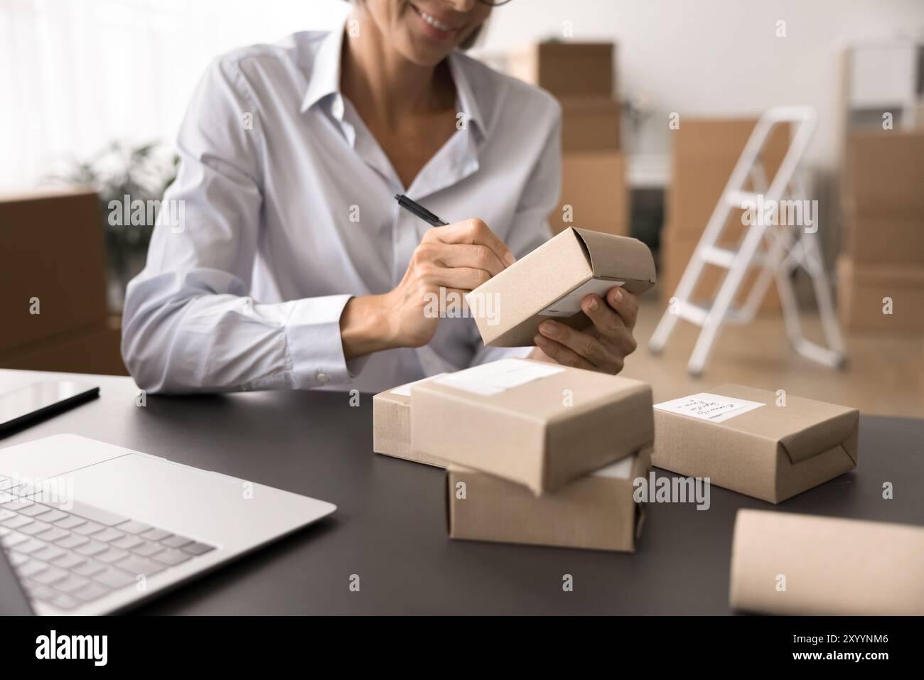 Una donna d'affari prepara ha ordinato pacchi ai clienti per la spedizione Foto Stock