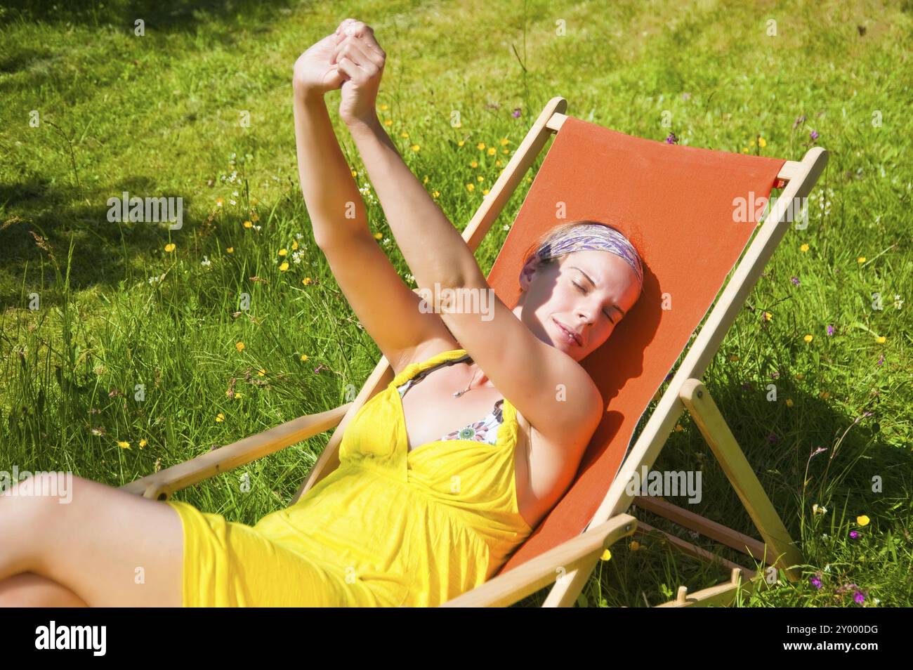 Una giovane donna che ama la sdraio al sole. Ambiente tranquillo, perfetto per il riposo e il relax Foto Stock