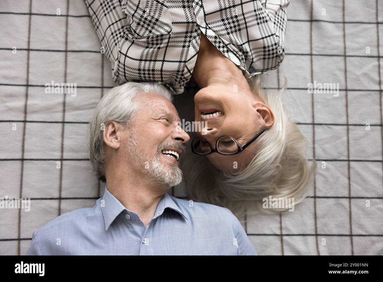 Amando una coppia di 65 anni sdraiata sul letto, vista dall'alto Foto Stock