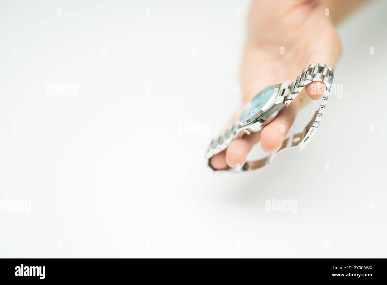 Uomo che regge un moderno orologio blu tiffany argento di lusso su sfondo bianco Foto Stock