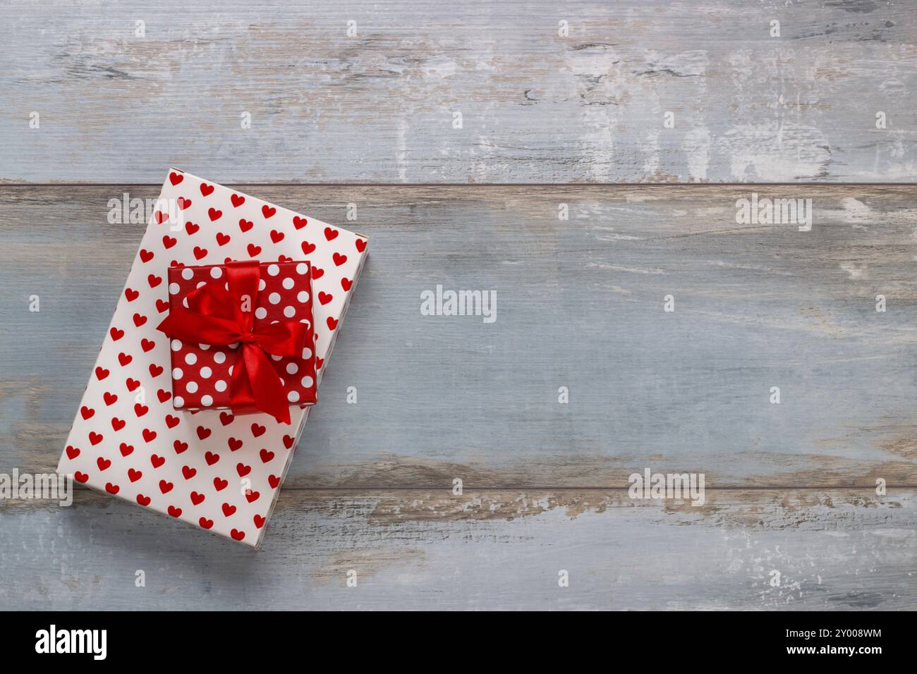 Scatole regalo confezionate in carta di polkadots con nastri su sfondo in legno, stile vintage retrò Foto Stock