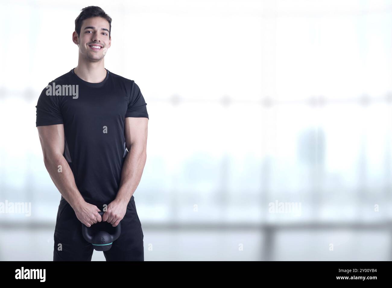 Montare maschio tenendo un kettlebell, in una palestra Foto Stock