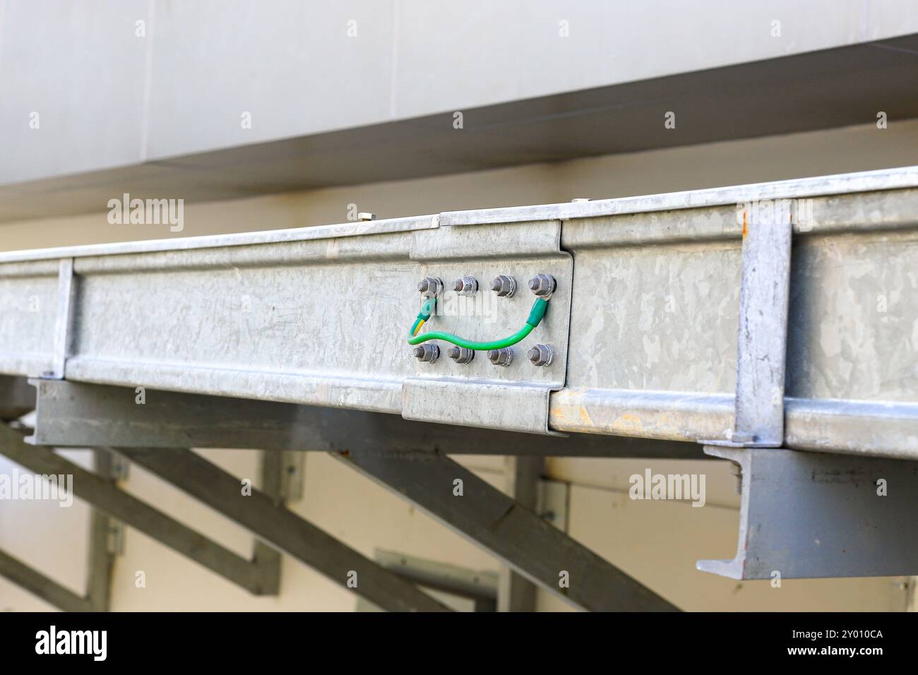 Filo di massa giallo-verde collegato sul coperchio tra la superficie metallica per evitare l'elettricità. Foto Stock