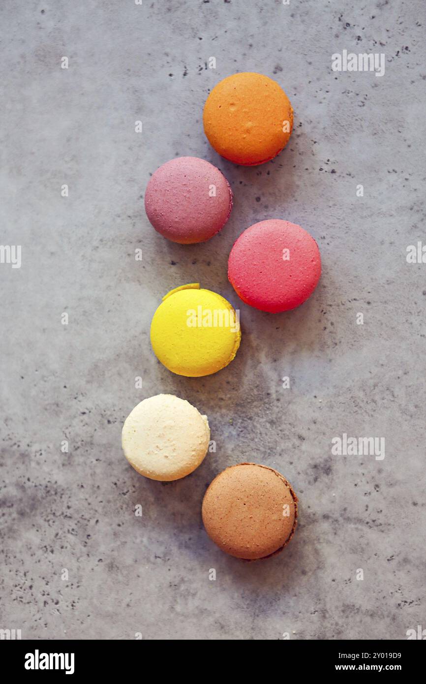 Pila di colorati macarons francese al buio su un sfondo rustico, il fuoco selettivo Foto Stock