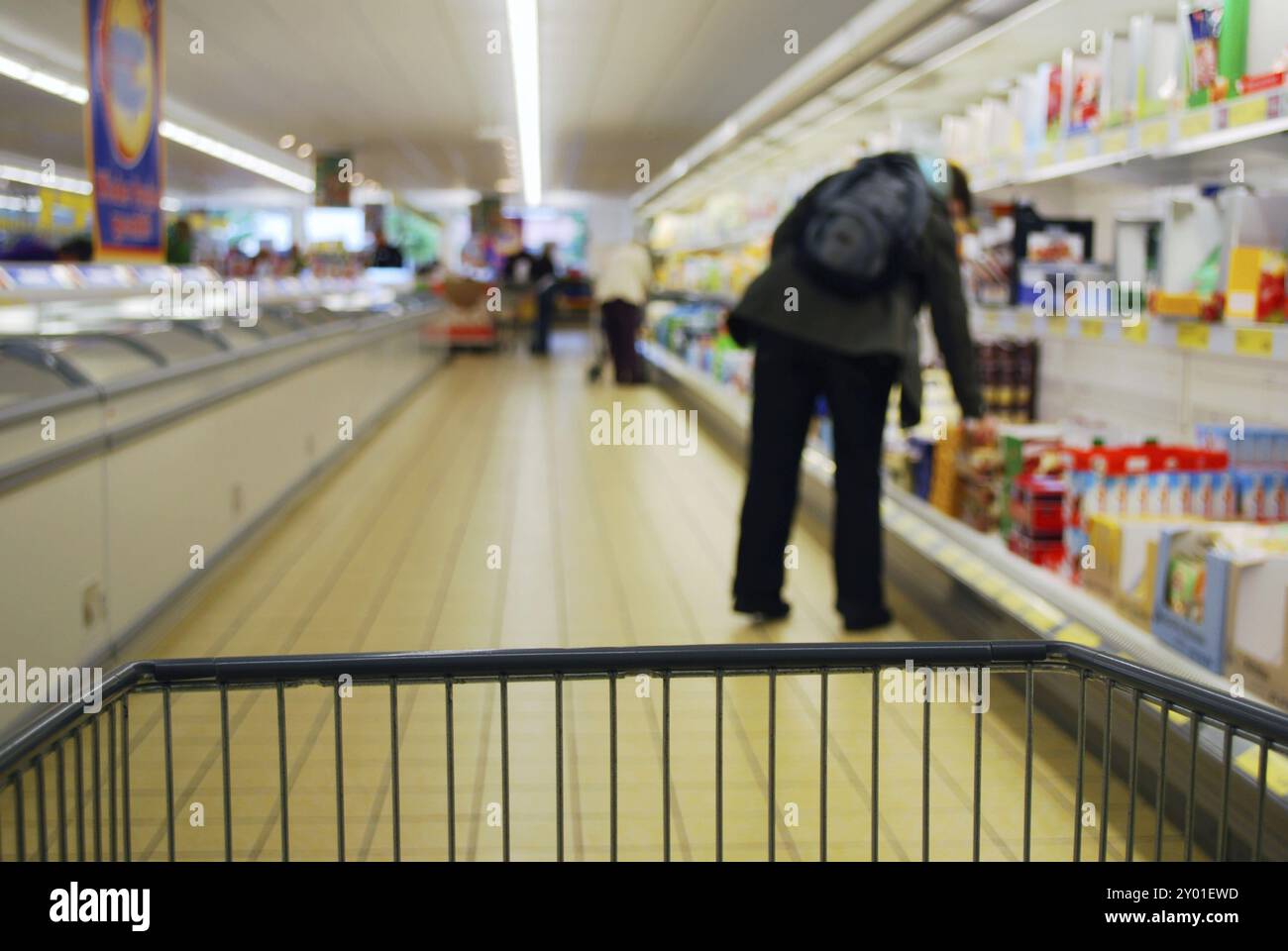 Persone in supermercato con scaffali refrigeranti e frigoriferi Foto Stock