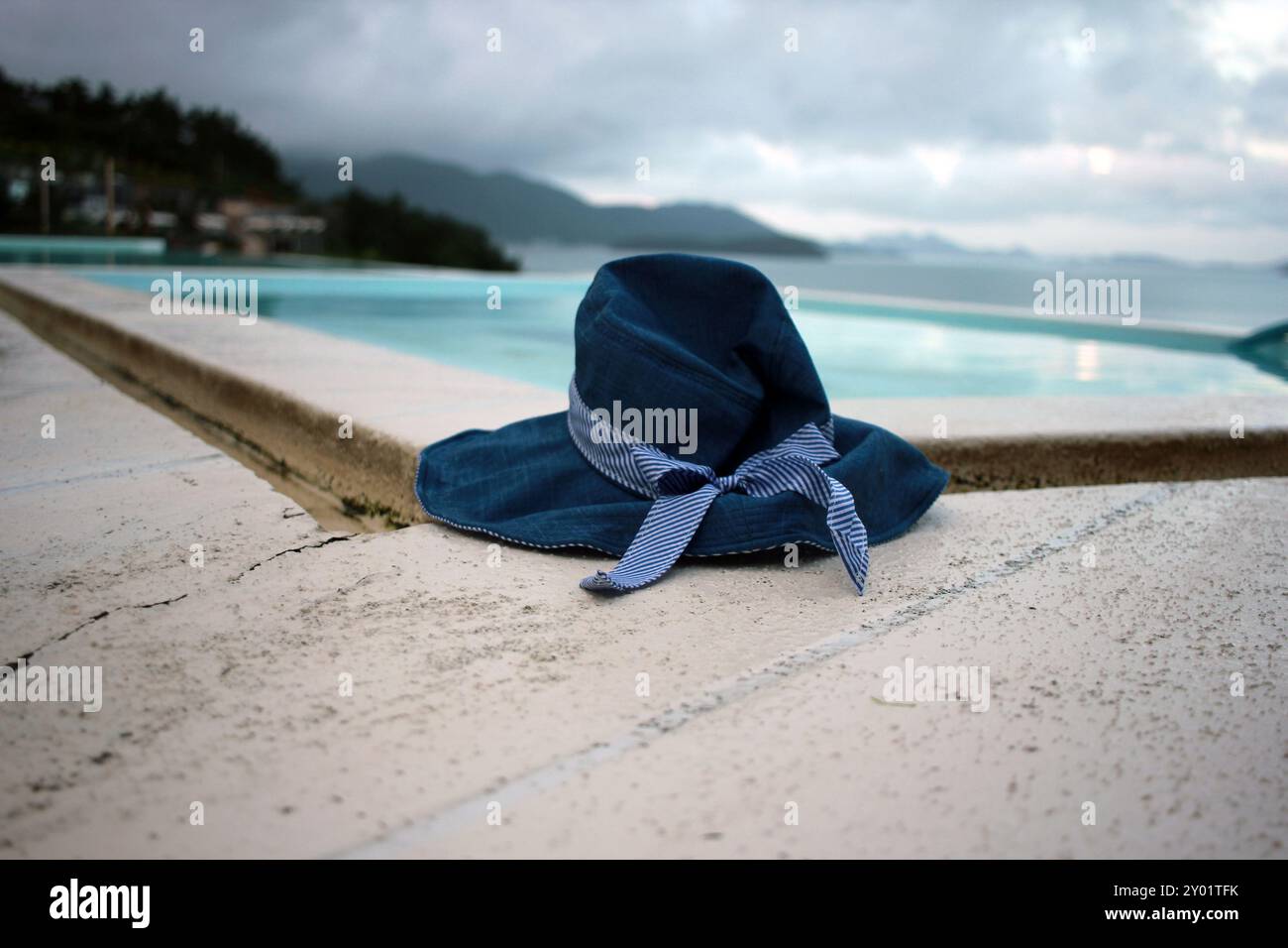 Dolsan-eup, Yeosu-si, Corea del Sud - 26 luglio 2024: Giovane donna che guarda l'alba in un resort con piscina affacciata sul mare di Yeosu Foto Stock