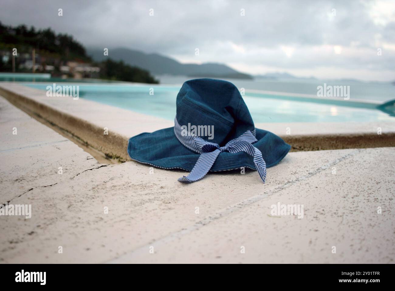 Dolsan-eup, Yeosu-si, Corea del Sud - 26 luglio 2024: Giovane donna che guarda l'alba in un resort con piscina affacciata sul mare di Yeosu Foto Stock