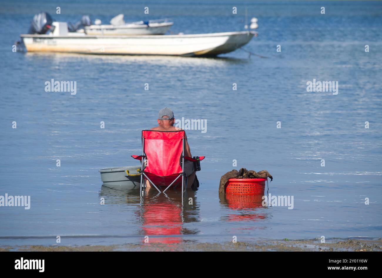 Un uomo si rilassa dopo una giornata di scavo di vongole al largo di Scudder Road, a Barnstable, Massachusetts, a Cape Cod Foto Stock