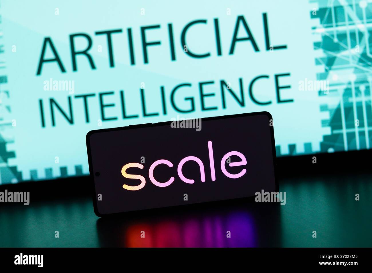 In questa immagine, il logo Scale ai viene visualizzato sullo schermo di uno smartphone con il testo intelligenza artificiale sullo sfondo. Foto Stock