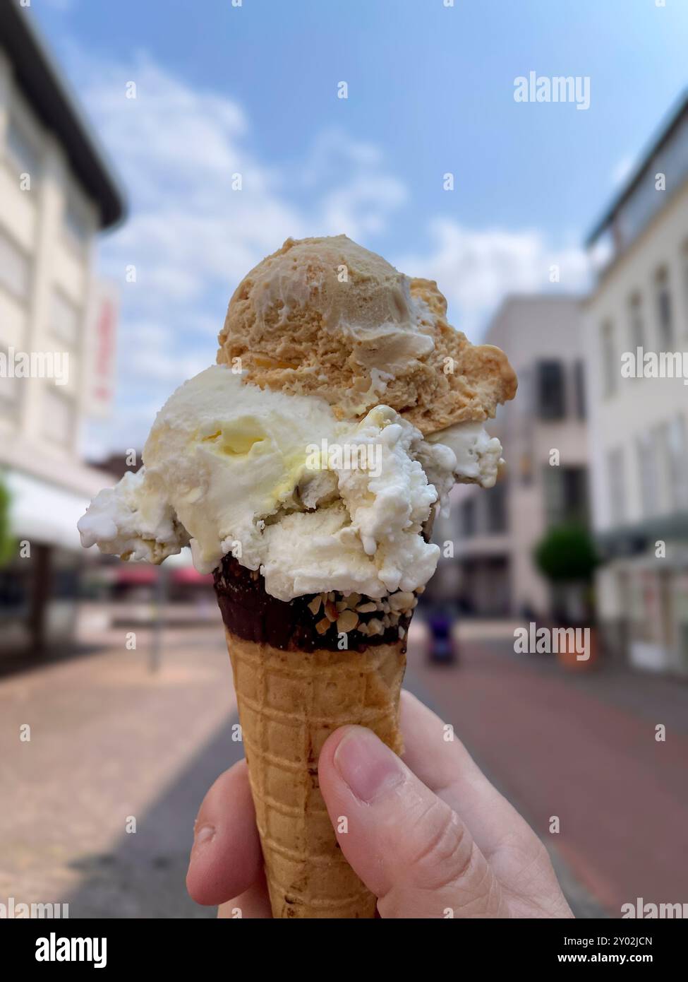 Walnuss, Vanille, Schokolade, pistatzie Eiscreme in einer Waffel in der Hand gehalten Foto Stock