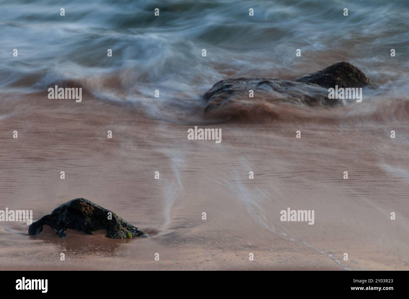 Onde che si infrangono contro le rocce su una spiaggia incontaminata a Kauai Hawaii Foto Stock