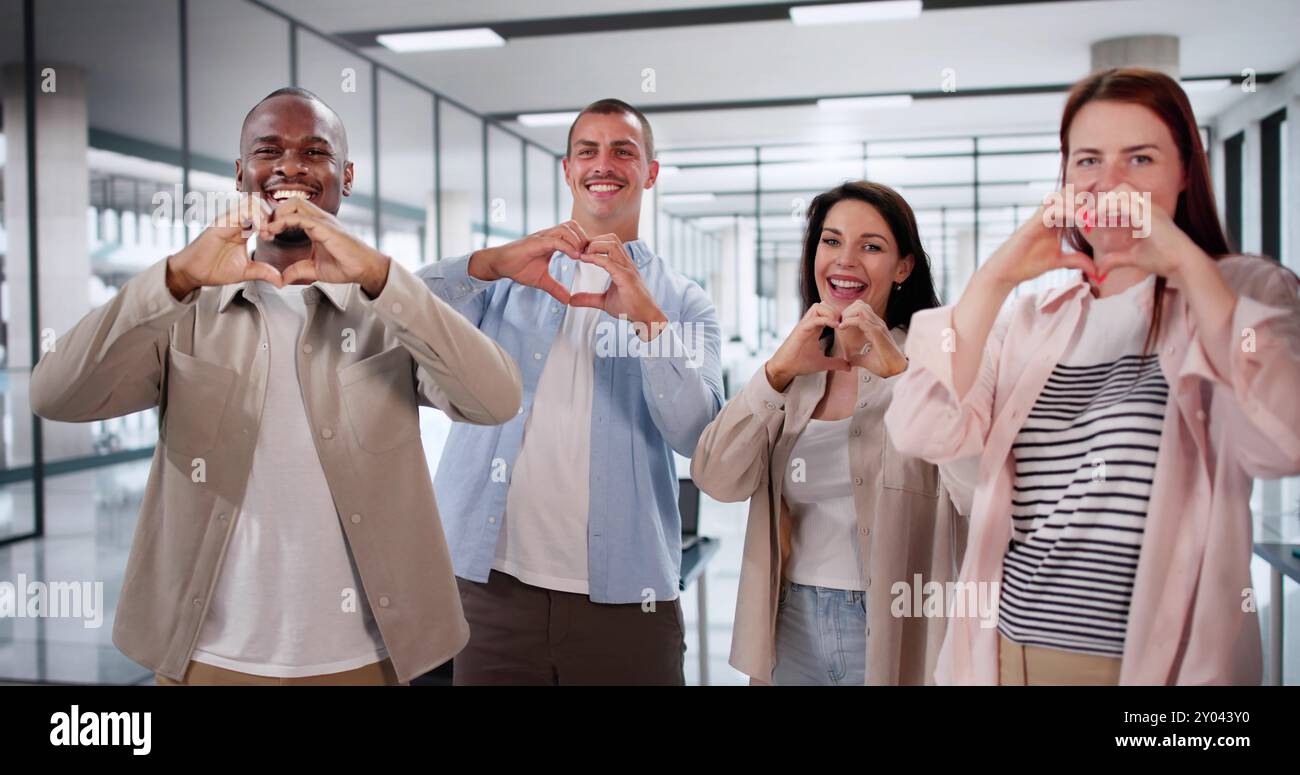 Dipendenti aziendali felici che creano cuori con le mani. Comunità sul luogo di lavoro Foto Stock