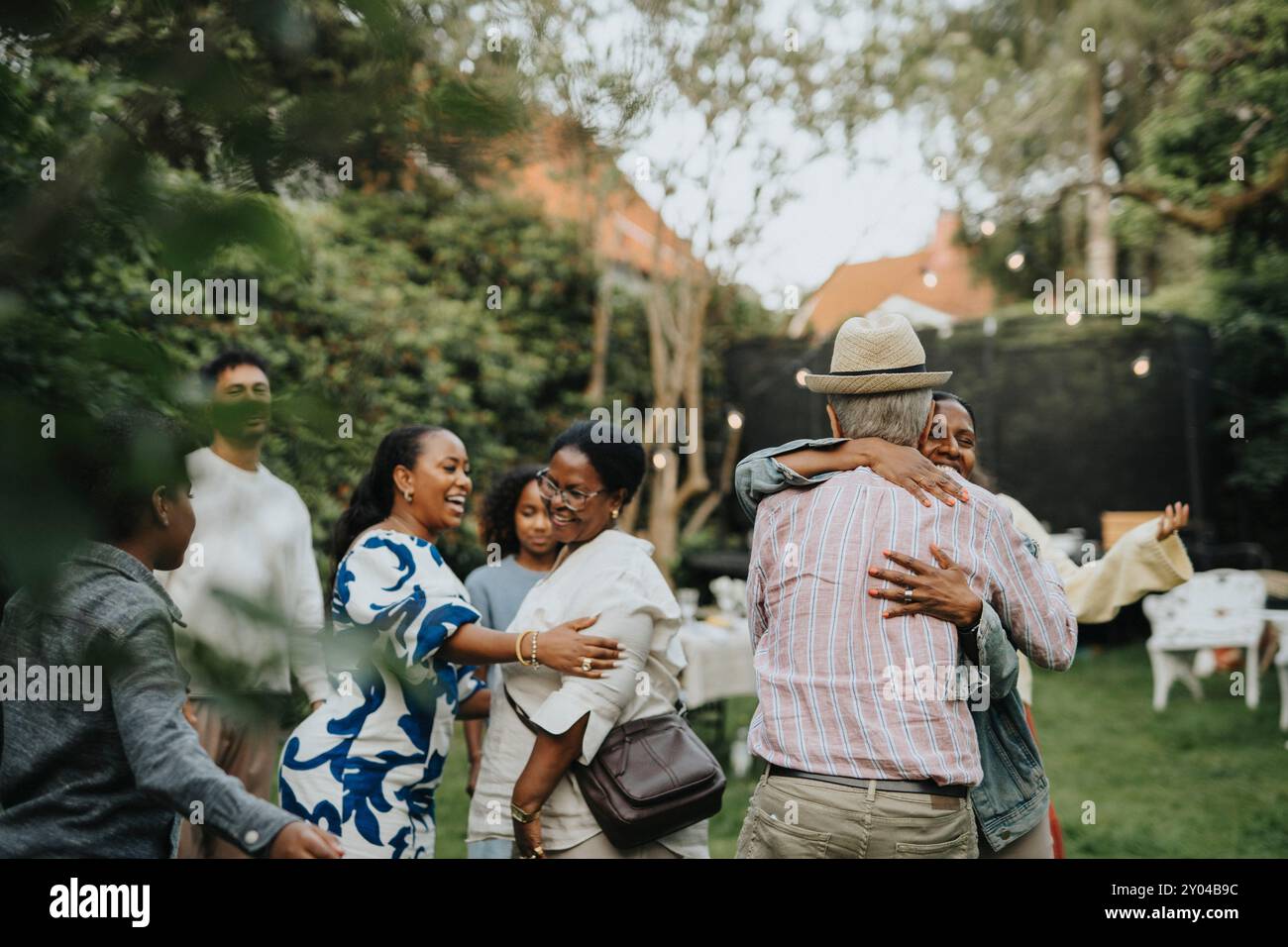 I membri della famiglia felici si salutano a vicenda alla festa in giardino Foto Stock