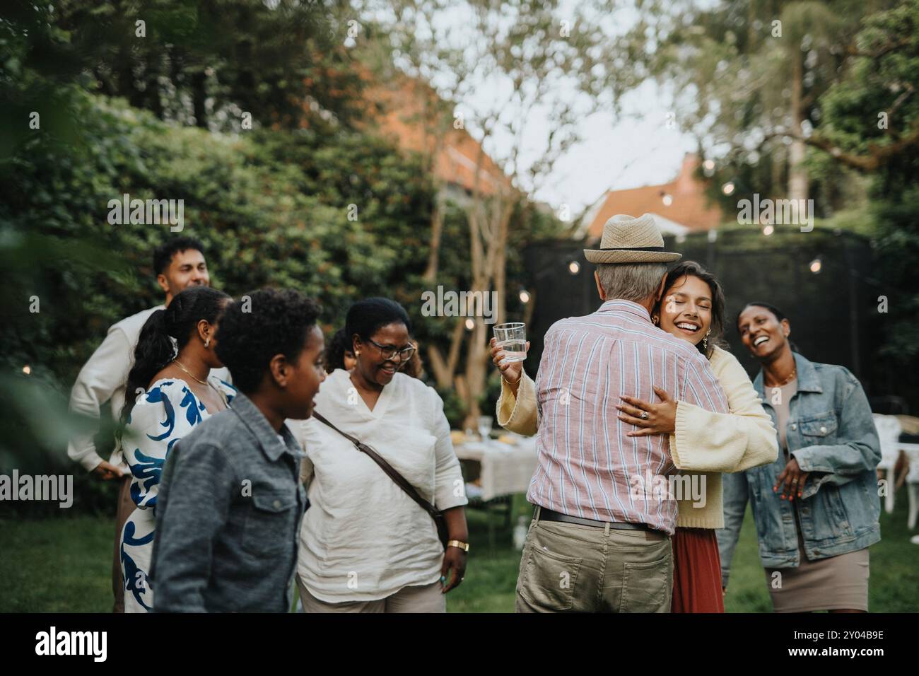 I membri della famiglia felici si salutano durante la riunione sociale alla festa in giardino Foto Stock