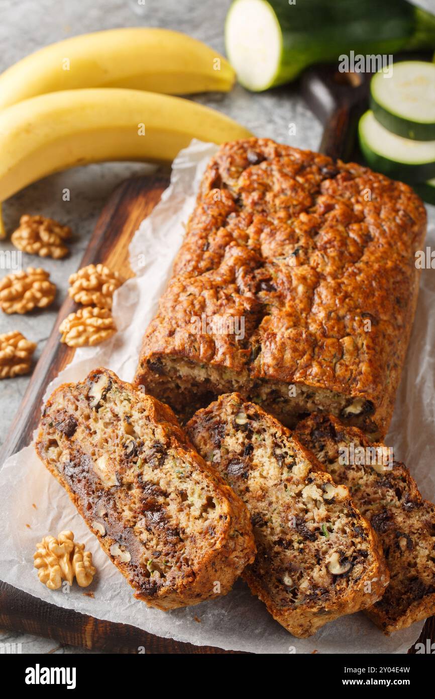 Pan di zucchero dolce, pane alla banana con noci e cioccolato fondente primo piano su tavola di legno. Verticale Foto Stock