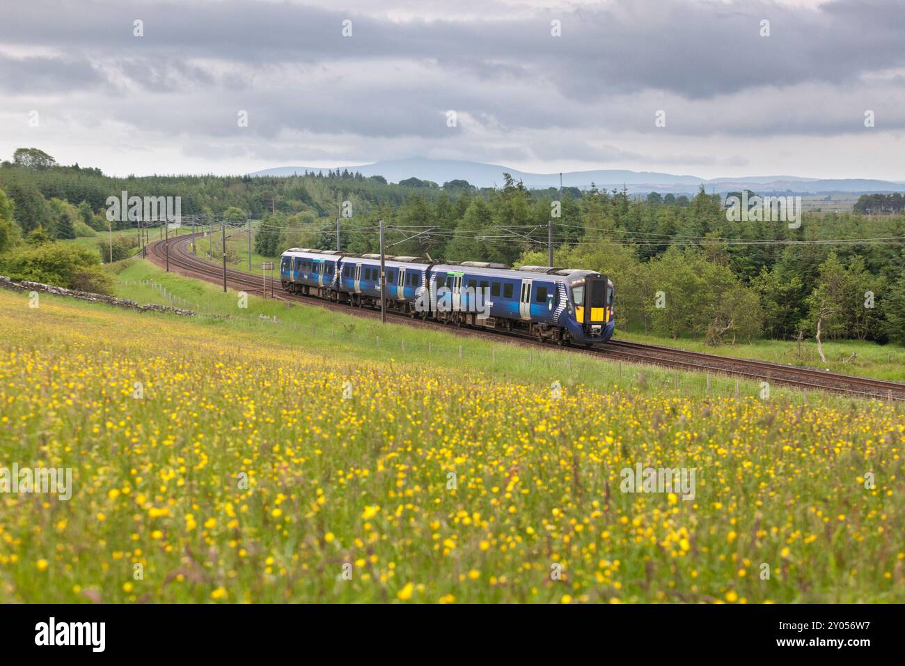 Treno elettrico multiunità ScotRail Siemens classe 385 che passa per la campagna di Auchengray, Scozia, Regno Unito Foto Stock