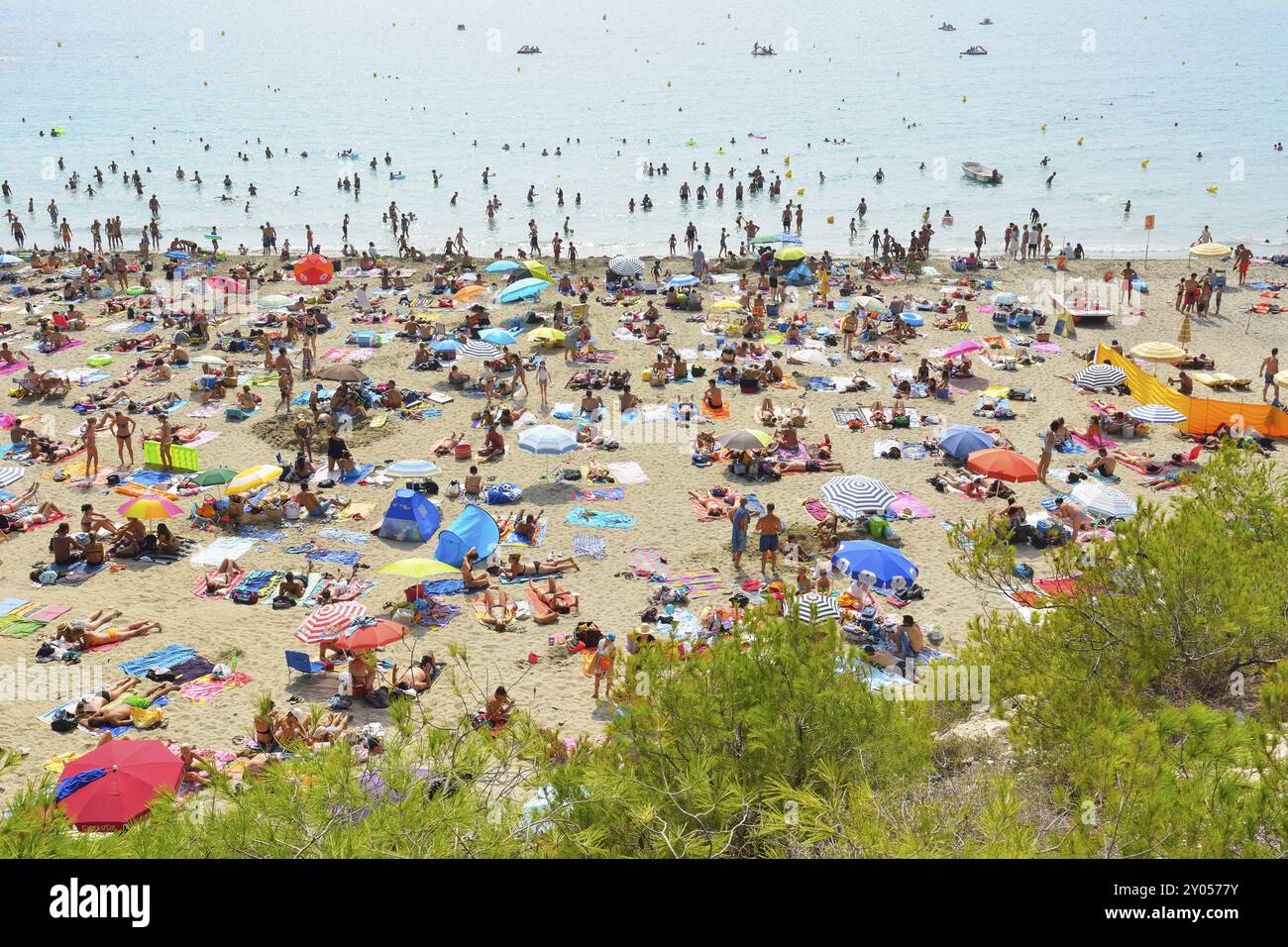 Una spiaggia affollata con molte persone che prendono il sole e nuotano, ombrelloni colorati e il mare sullo sfondo, Summer, Plage de Sainte Croix, la Couronne Foto Stock