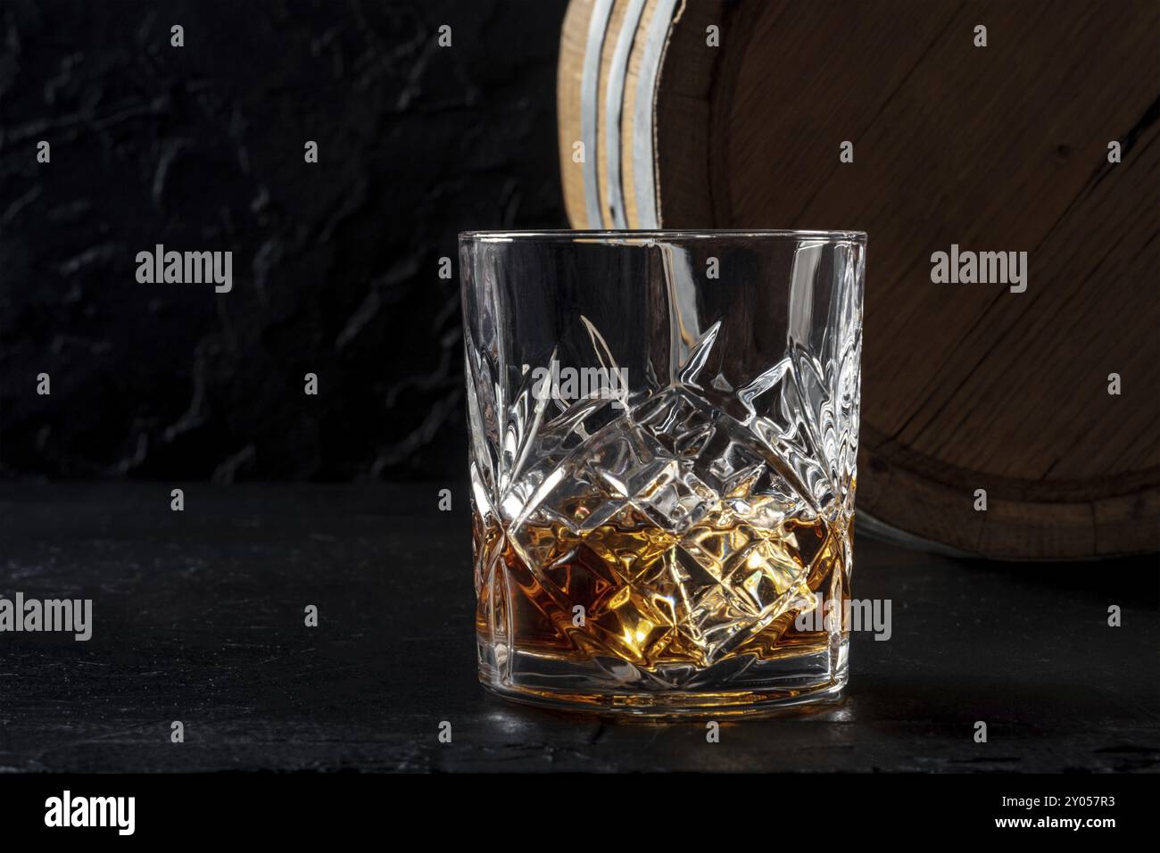 Frullare in un bicchiere con un barile. Whisky Bourbon e una botte su sfondo scuro, con spazio copia Foto Stock