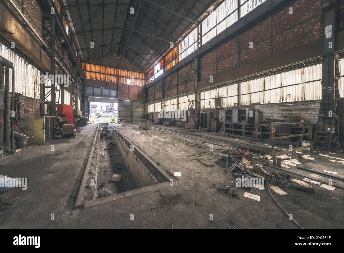 Capannone industriale scuro e abbandonato con strutture metalliche e rifiuti sul pavimento, acciaierie HF4, Lost Place, Dampremy, Charleroi, provincia di Hainaut, Foto Stock