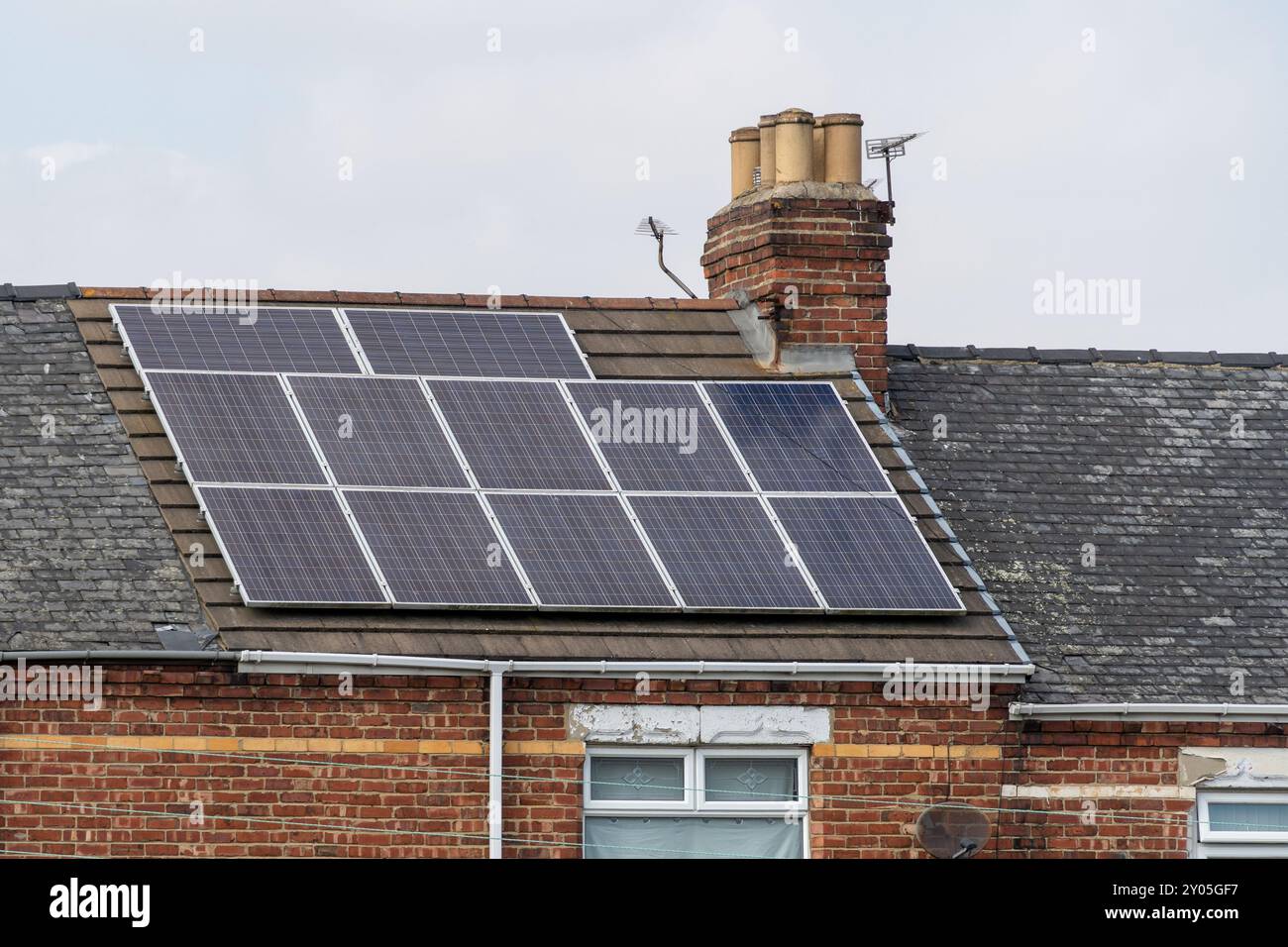 Pannelli solari sul tetto di una casa a schiera. Concetto di generazione di energia solare domestica o domestica. Foto Stock
